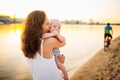 Happy family on the beach. Son child mother boy and baby hugging on beach near river or lake. Happy family on the beach. Mom and Royalty Free Stock Photo
