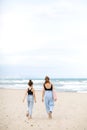 Happy family on beach vacation. Back view of mother and little daughter are walking together and holding hands on beach Royalty Free Stock Photo