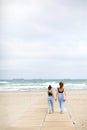 Happy family on beach vacation. Back view of mother and little daughter are walking together and holding hands on beach Royalty Free Stock Photo