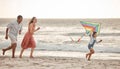 Happy family, beach vacation and child flying kite while running by the sea with her mother and father. Energy, fun and Royalty Free Stock Photo
