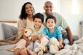 Happy family, bed and portrait of parents and children bonding in a bedroom in a house and playing together. Care Royalty Free Stock Photo