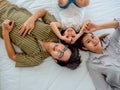 Happy family in bed room concept.top view father mother and daugther lying on bed looking pointing camera Royalty Free Stock Photo