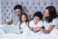 Happy family in bed shopping online Royalty Free Stock Photo