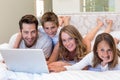 Happy family on the bed using laptop Royalty Free Stock Photo