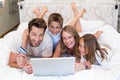 Happy family on the bed using laptop Royalty Free Stock Photo