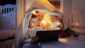 Happy family in bedroom at night watching cartoons on tablet computer. Family having time together, children with gadgets, Royalty Free Stock Photo