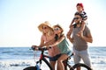 Family with bicycle on beach near sea