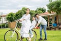Happy family with bicycle outdoors on summer day, Asian father and mother with daughter enjoying riding a bike outdoors in a park Royalty Free Stock Photo