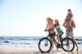 Family with bicycle on sandy beach near sea