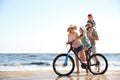 Happy family with bicycle on beach near sea