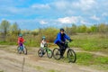 Happy family on bikes, father cycling with kids outdoors