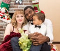 Happy family: black father, mom and baby boy by fireplace. Christmas