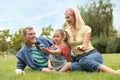 Happy family blowing soap bubbles in park on green grass Royalty Free Stock Photo