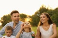 Happy family blowing soap bubbles in park at sunset Royalty Free Stock Photo