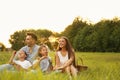 Happy family blowing soap bubbles in park at sunset Royalty Free Stock Photo