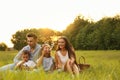 Happy family blowing soap bubbles in park at sunset Royalty Free Stock Photo