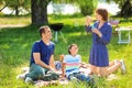 Happy family blowing soap bubbles on summer picnic in park Royalty Free Stock Photo