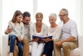 Happy family with book or photo album at home Royalty Free Stock Photo