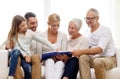 Happy family with book or photo album at home Royalty Free Stock Photo