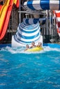 Happy family at the bottom of striped waterslide Royalty Free Stock Photo