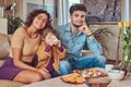 Family Breakfast. Young attractive family having breakfast at home sitting on a sofa. Royalty Free Stock Photo