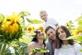 Happy family - brothers, sister and mom have fun on the field among the sunflowers. Summer vacation time