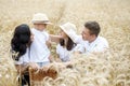 Happy family - brothers, sister and mom have fun on the wheat field. Summer vacation time