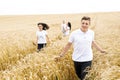 Happy family - brothers, sister and mom have fun on the wheat field. Summer vacation time