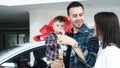 Happy family after buying a new car. Dad shows the keys to the new car Royalty Free Stock Photo