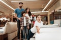 Happy family buys new orthopedic mattress in furniture store. Blissful family choosing mattresses in store. Royalty Free Stock Photo