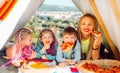 Happy family at camping. Eatiing pizza outdoor. Mother and kid in tent. Parenting concept. Royalty Free Stock Photo