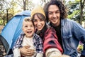 Happy family camping in the forest taking selfie portrait together Royalty Free Stock Photo