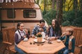 Happy family on a camping trip relaxing in the autumn forest. Camper trailer. Fall season outdoors trip Royalty Free Stock Photo