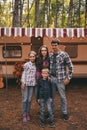 Happy family on a camping trip relaxing in the autumn forest. Camper trailer. Fall season outdoors trip Royalty Free Stock Photo