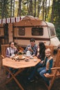 Happy family on a camping trip relaxing in the autumn forest. Camper trailer. Fall season outdoors trip Royalty Free Stock Photo