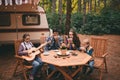 Happy family on a camping trip relaxing in the autumn forest. Camper trailer. Fall season outdoors trip Royalty Free Stock Photo