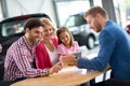 Happy family in car dealership choosing their new car Royalty Free Stock Photo