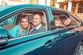 Happy family in the car. Mother father son and daughter looking at you camera smiling about to go in a vacation, travelling with Royalty Free Stock Photo