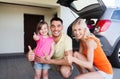 Happy family with car showing thumbs up at parking Royalty Free Stock Photo