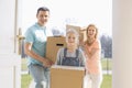 Happy family with cardboard boxes entering new home