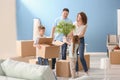 Happy family with cardboard boxes indoors. Moving into new house Royalty Free Stock Photo