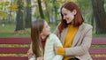 Happy family Caucasian mother with little daughter hugging smiling laughing at park bench mom babysitter woman cuddling Royalty Free Stock Photo