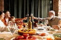 Happy family celebrate Thanksgiving day, sitting at table with roasted turkey and holiday traditional food, dishes Royalty Free Stock Photo