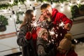 Happy family celebrates christmas in nature and holds sparklers. Parents with three sons travels in a van. Royalty Free Stock Photo