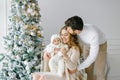 Happy family celebrates Christmas and New Year at home in the living room near the Christmas tree. Family portrait of dad, mom and Royalty Free Stock Photo