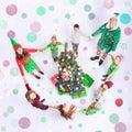 Happy family celebrating Christmas a round Cristmas tree. Royalty Free Stock Photo