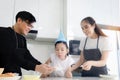 Happy family celebrating daughter girl birthday at kitchen together, father holding cake with candles for child kid to blow, Royalty Free Stock Photo