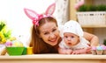 Happy family celebrating easter mother and baby with bunny ears