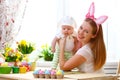 Happy family celebrating easter mother and baby with bunny ears