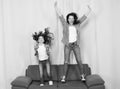 Happy family celebrating mothers day. Happy mother and daughter jumping on sofa. Mother and child enjoying happy mothers Royalty Free Stock Photo